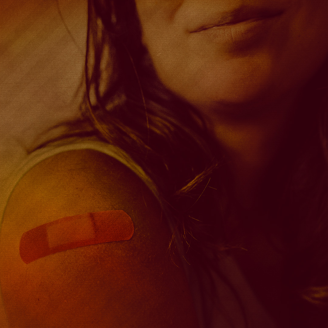 Colorized, closeup photograph of a person's shoulder with a bandage on it