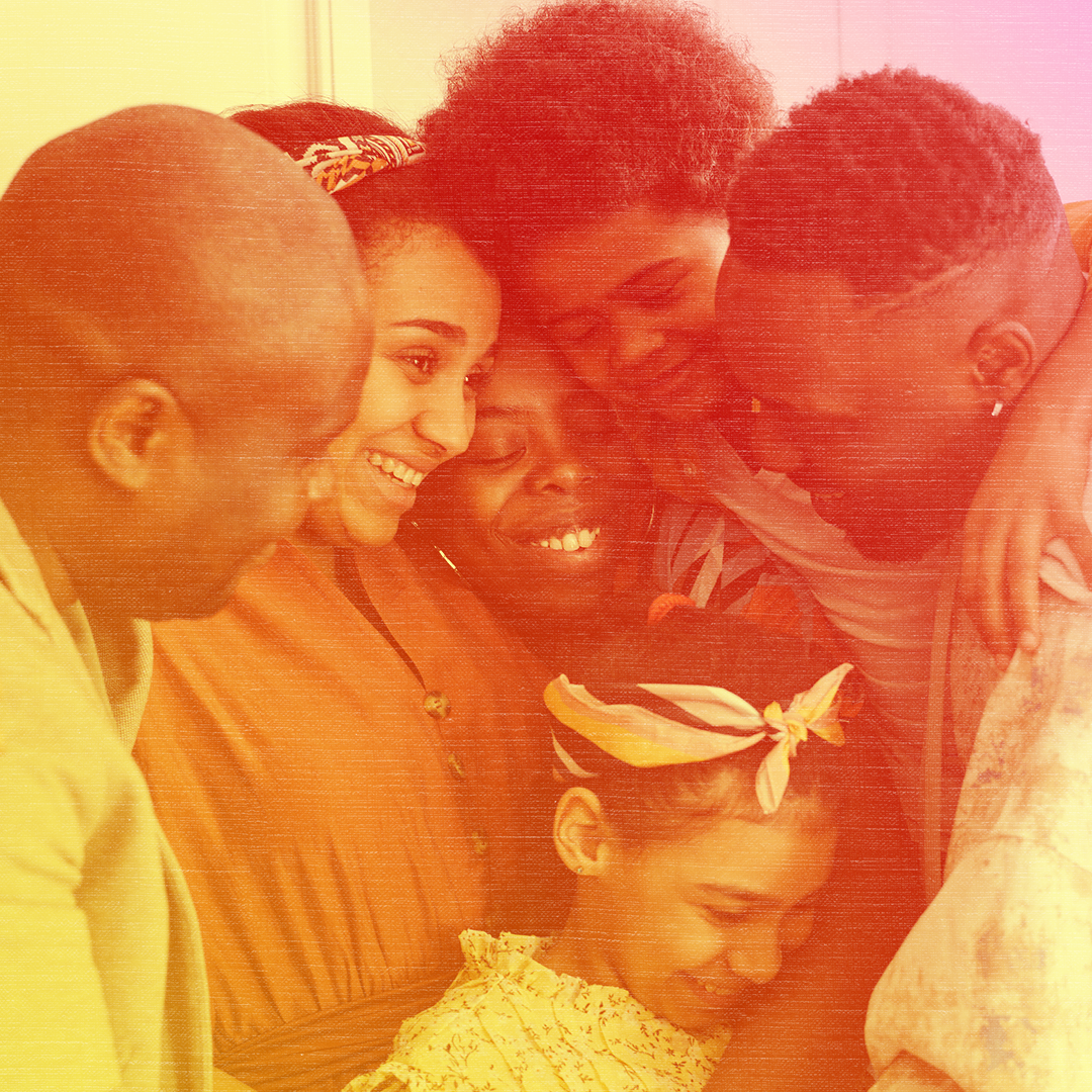 Red colorized photo of a Black family of six including a few young kids hugging each other.