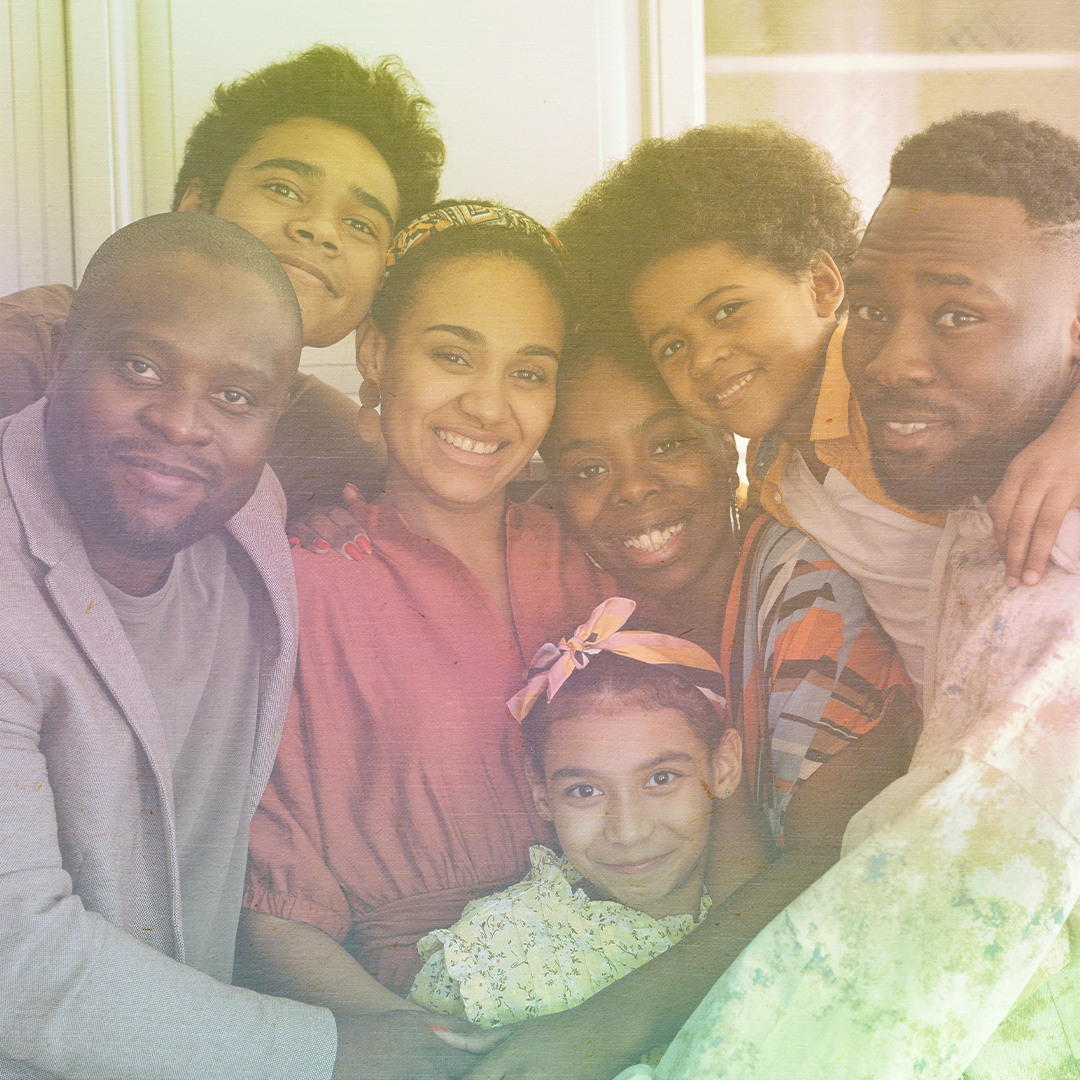 color photo of a Black family with a man and woman and five children all embracing and smiling