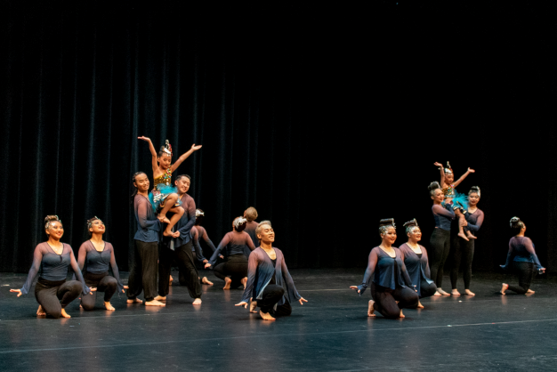 A group of dancers perform onstage