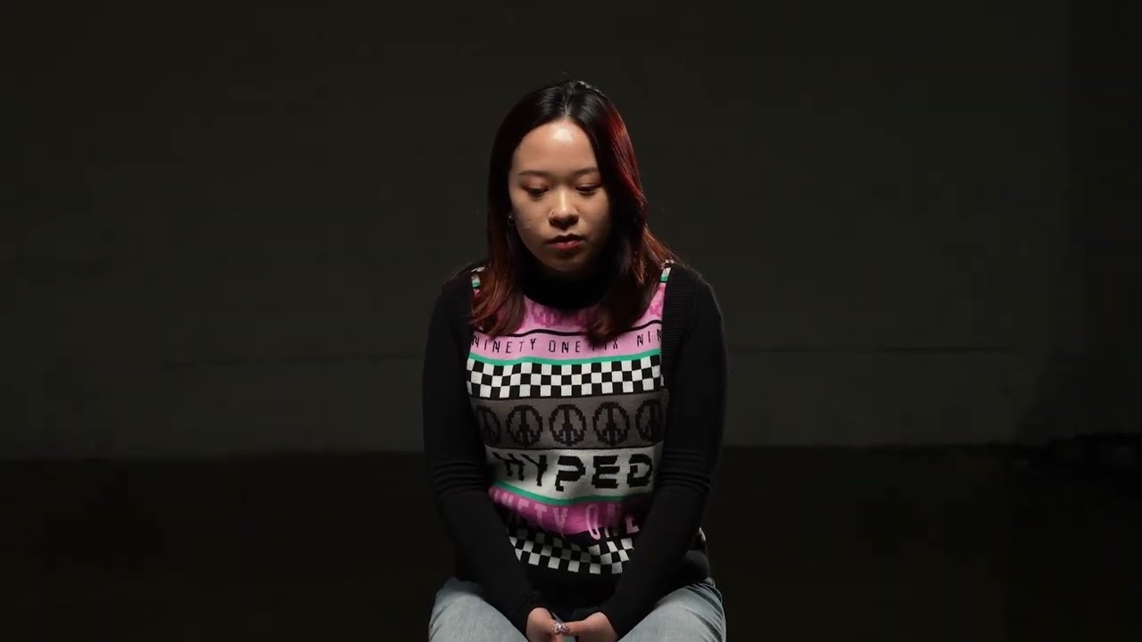 A young Asian woman sits in front of the  camera
