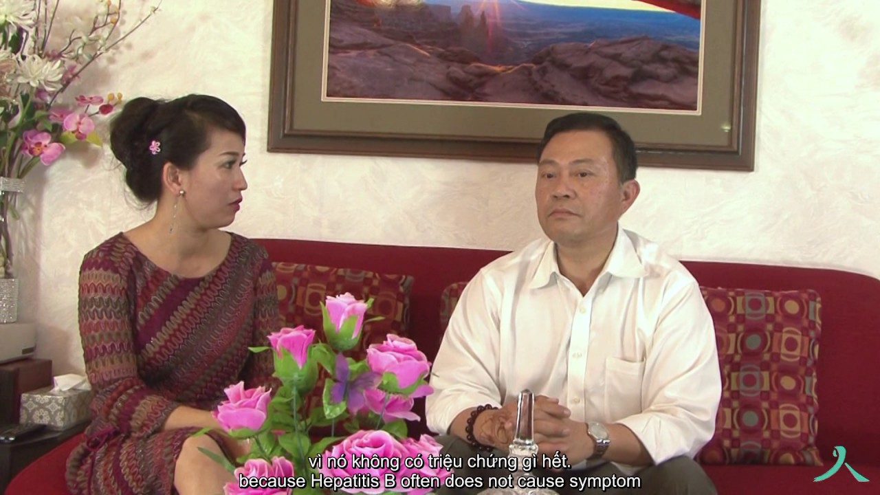 A Vietnamese American couple have a conversation on a couch.