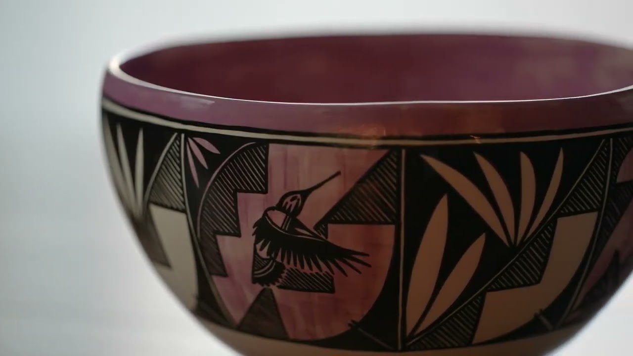 A ceramic bowl engraved with images of a bird and plants. 