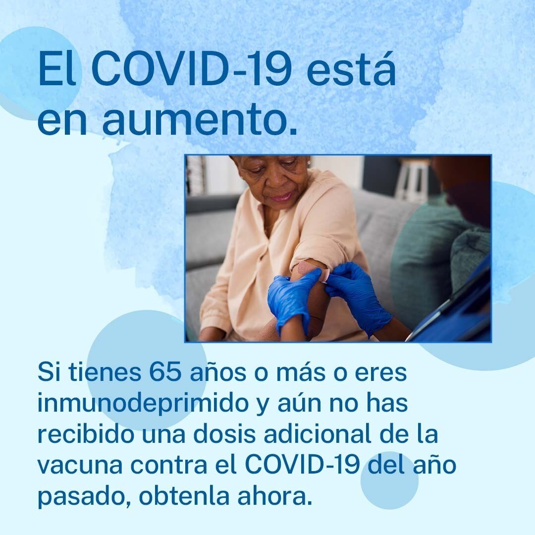 An older Black woman gets an adhesive bandage on her arm from a Black healthcare provider. Spanish text reads, "If you're 65 or older or immunocompromised and still have not yet recieved an additional dose of last year's COVID-19 vaccine, get it now. "