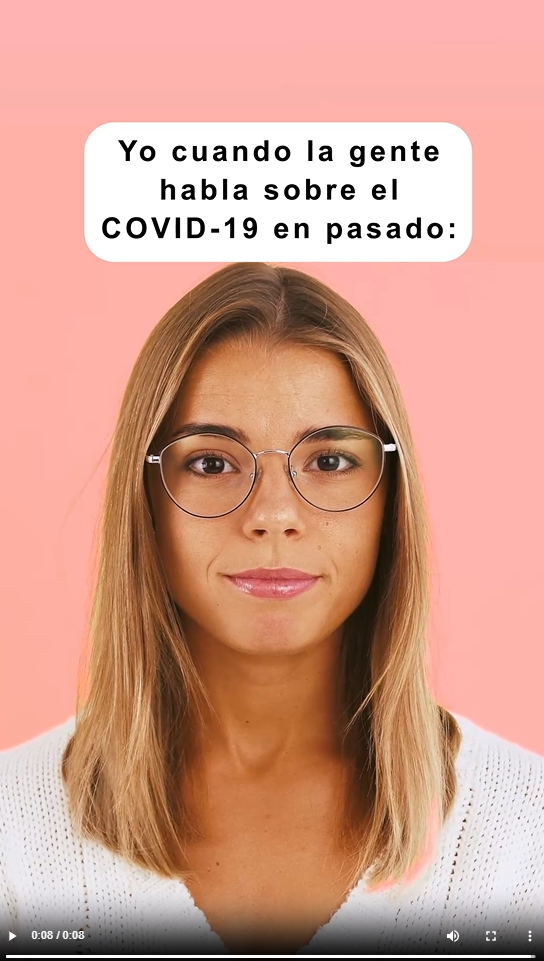 Image shows a young white woman wearing glasses.  She gestures later in the video showing her disagreement with others talking about COVID in the past tense.