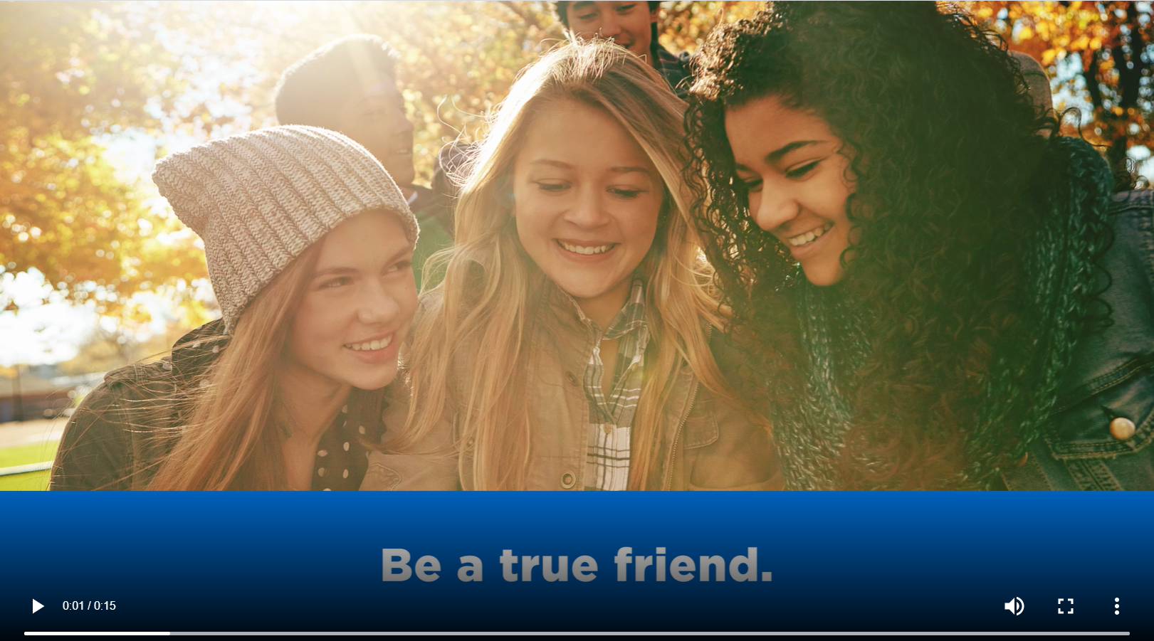 A group a friends smiles around a cell phone. Text reads, "Be a true friend."