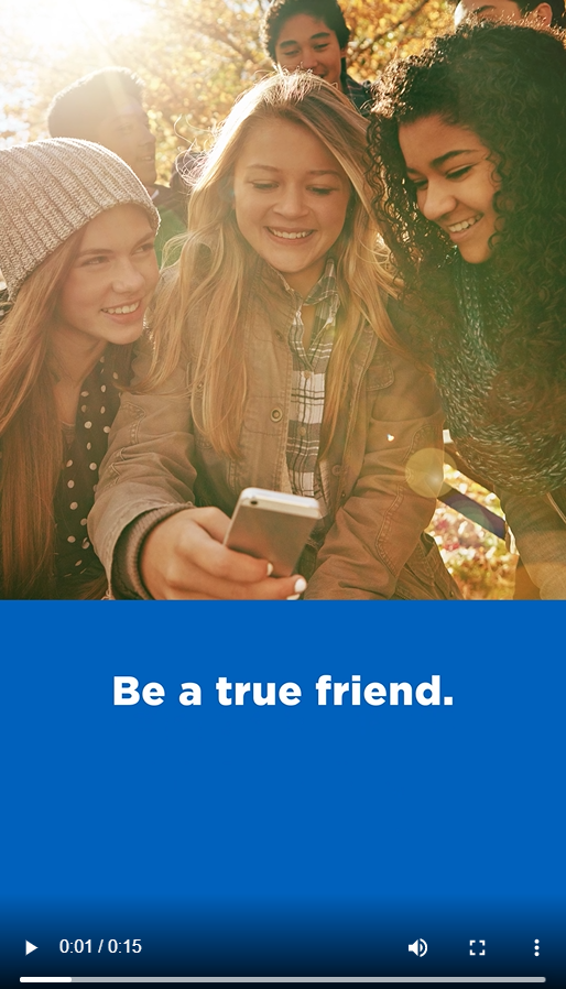 A group a friends smiles around a cell phone. Text reads, "Be a true friend."