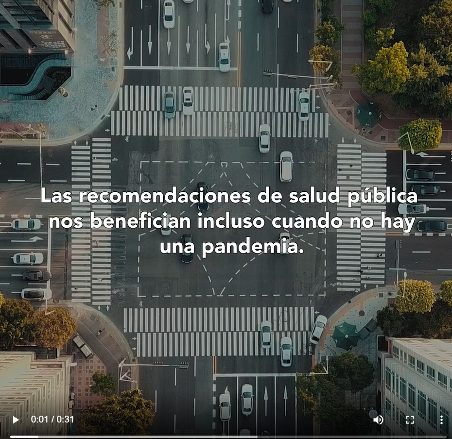 Image shows an aerial view of a busy intersection, with the words in Spanish " Public health guidelines benefit us even when there isn't a pandemic" against the backdrop