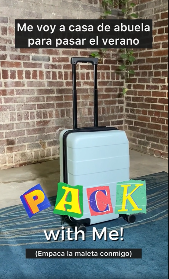 A blue suitcase underneath a title reading in Spanish, "Pack with Me!"  and a subtitle in Spanish. Spanish caption reads "I'm heading to Abuela's for the summer."