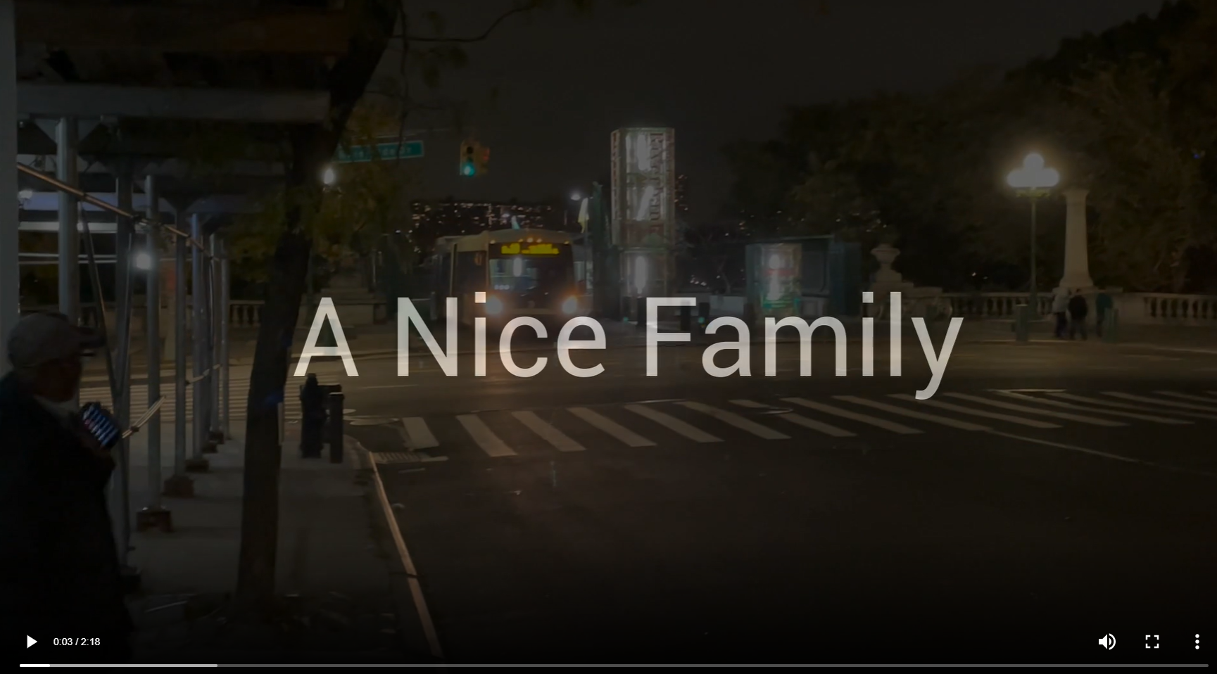 Video titled "A Nice Family" over a background of a city street. 