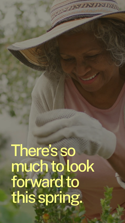 Video still shows an older Black woman wearing a sunhat and gloves, smiling and gardening outside in the sun.