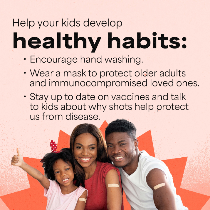 A Black father, mother and young daughter with big smiles sit side by side, all showing off bandages on their shoulders. The daughter is holding up a big thumbs up.