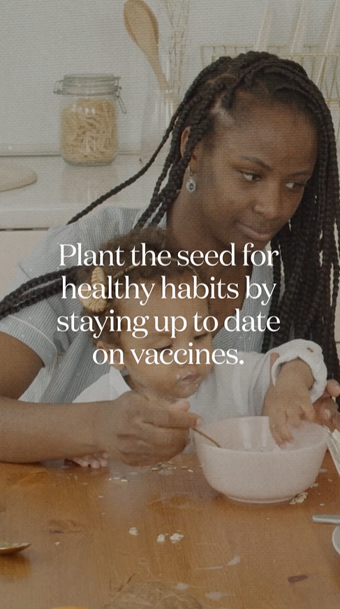 Video still shows a Black mother feeding her daughter oatmeal at the kitchen table.