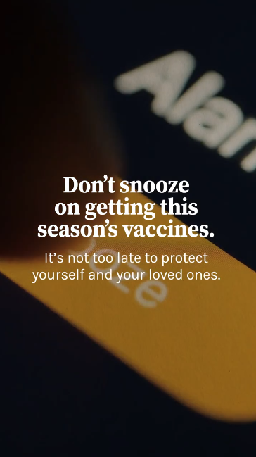 Video shows a montage of people running late: hitting the snooze on their alarm, a clock rapidly advancing, getting stuck in traffic, and running to catch an elevator. Overlaid text reads: "Don’t snooze on getting this season’s vaccines. It’s not too late to protect yourself and your loved ones."