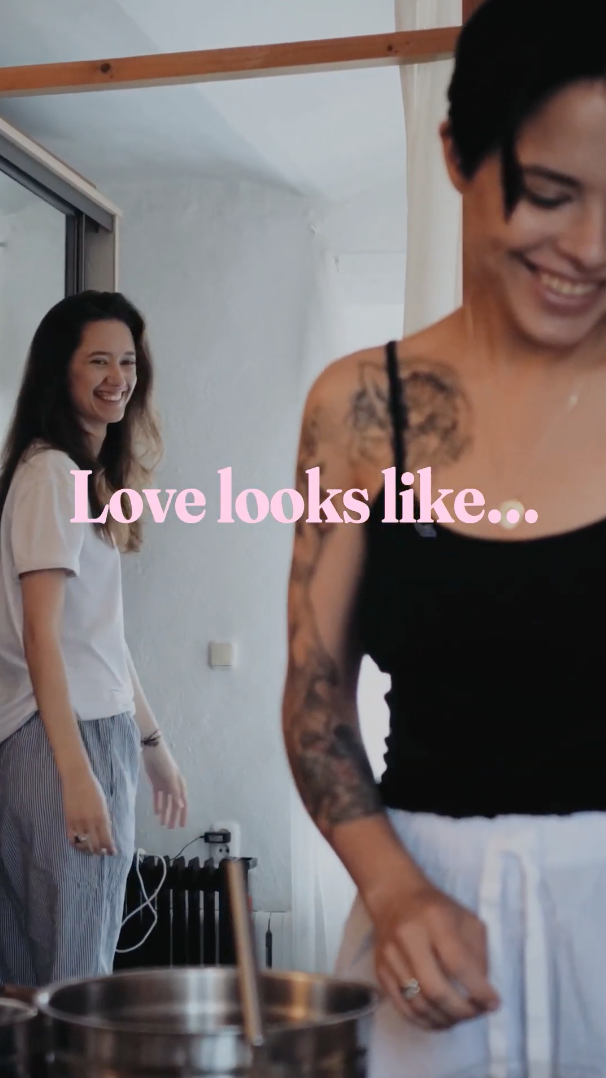 Montage-style video of different couples showing love. Text overlaid reads: “Love looks like… Home-cooked meals, tight hugs, fresh flowers, romantic dates, and getting vaccinated against COVID-19 and the flu—to keep each other safe all season.”