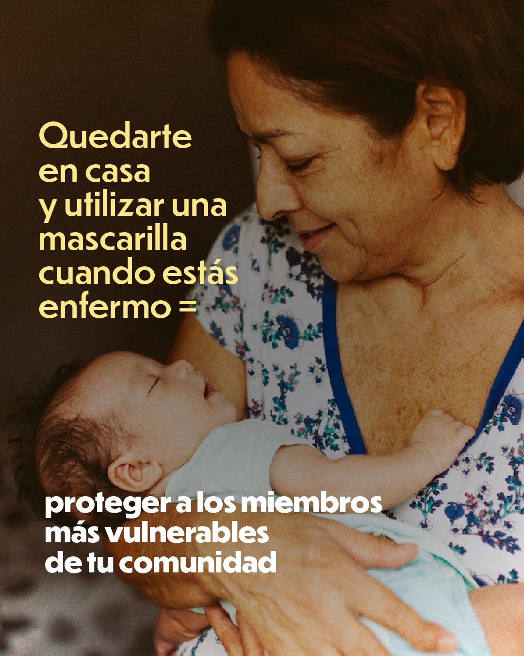 Photo of an older adult holding a baby. Text reads: “Staying home and wearing a mask when sick = protecting the most vulnerable members of your comunidad.”
