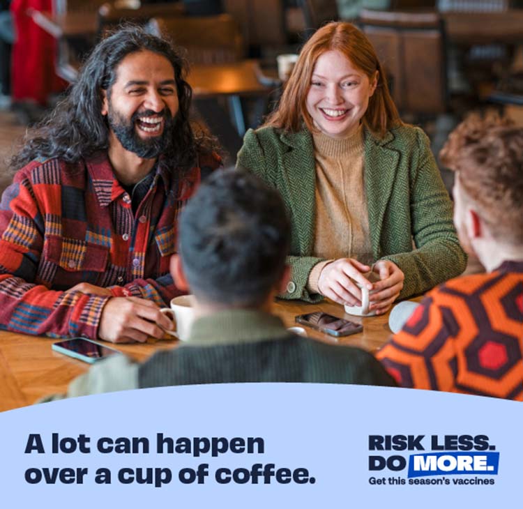 group of men and women laughing at a table in a coffee shop