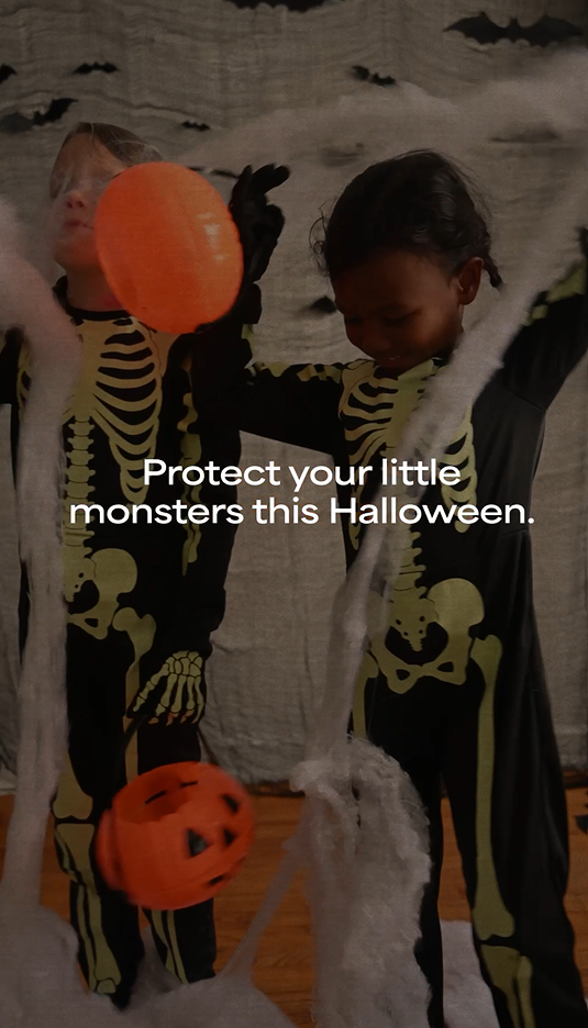 Image of a Black girl and a white girl both dressed up as skeletons for Halloween