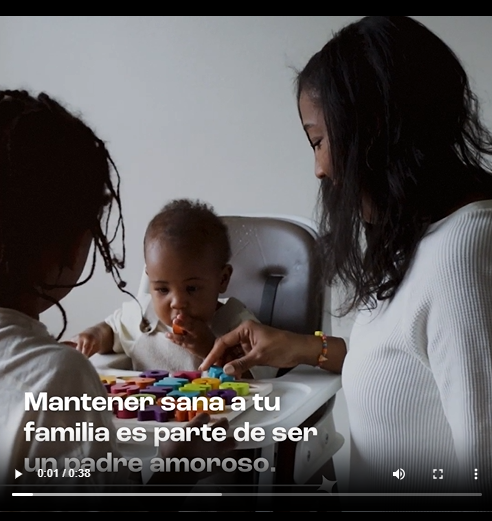 A Black mother and child play with infant sitting in high chair