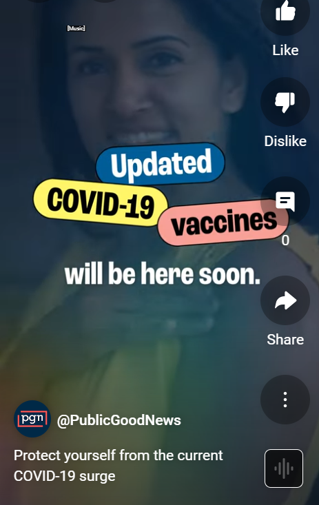 Video still containing an image of a white woman smiling at the camera and showing off the bandage covering her vaccine location on her arm.