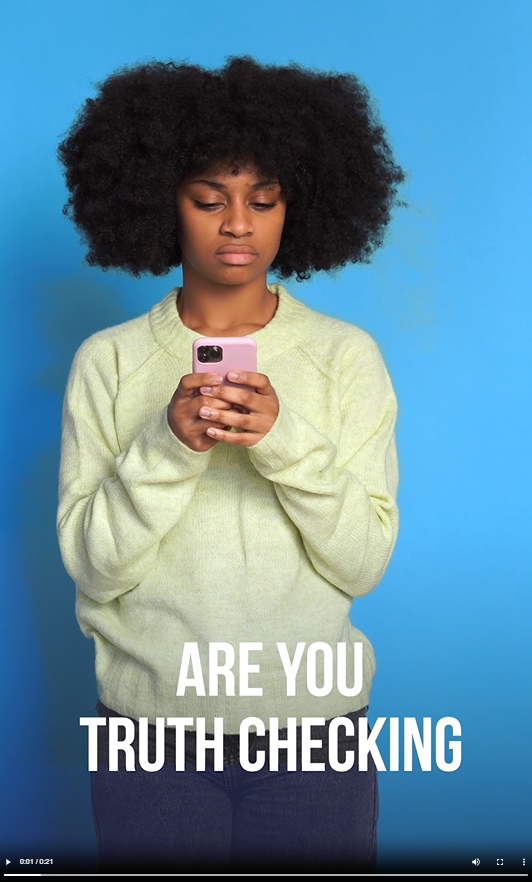 A young Black woman looks at her phone with a skeptical expression on her face