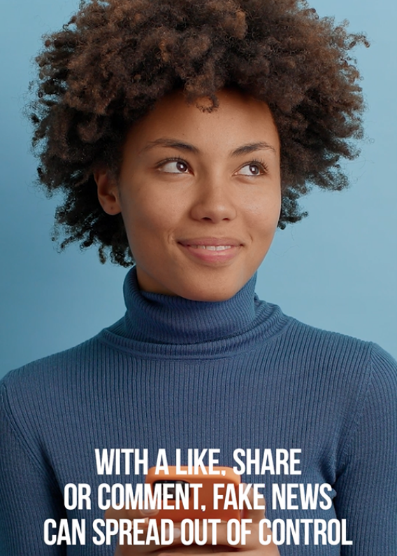 Image of a black woman in a dark blue turtleneck, holding her phone and smiling