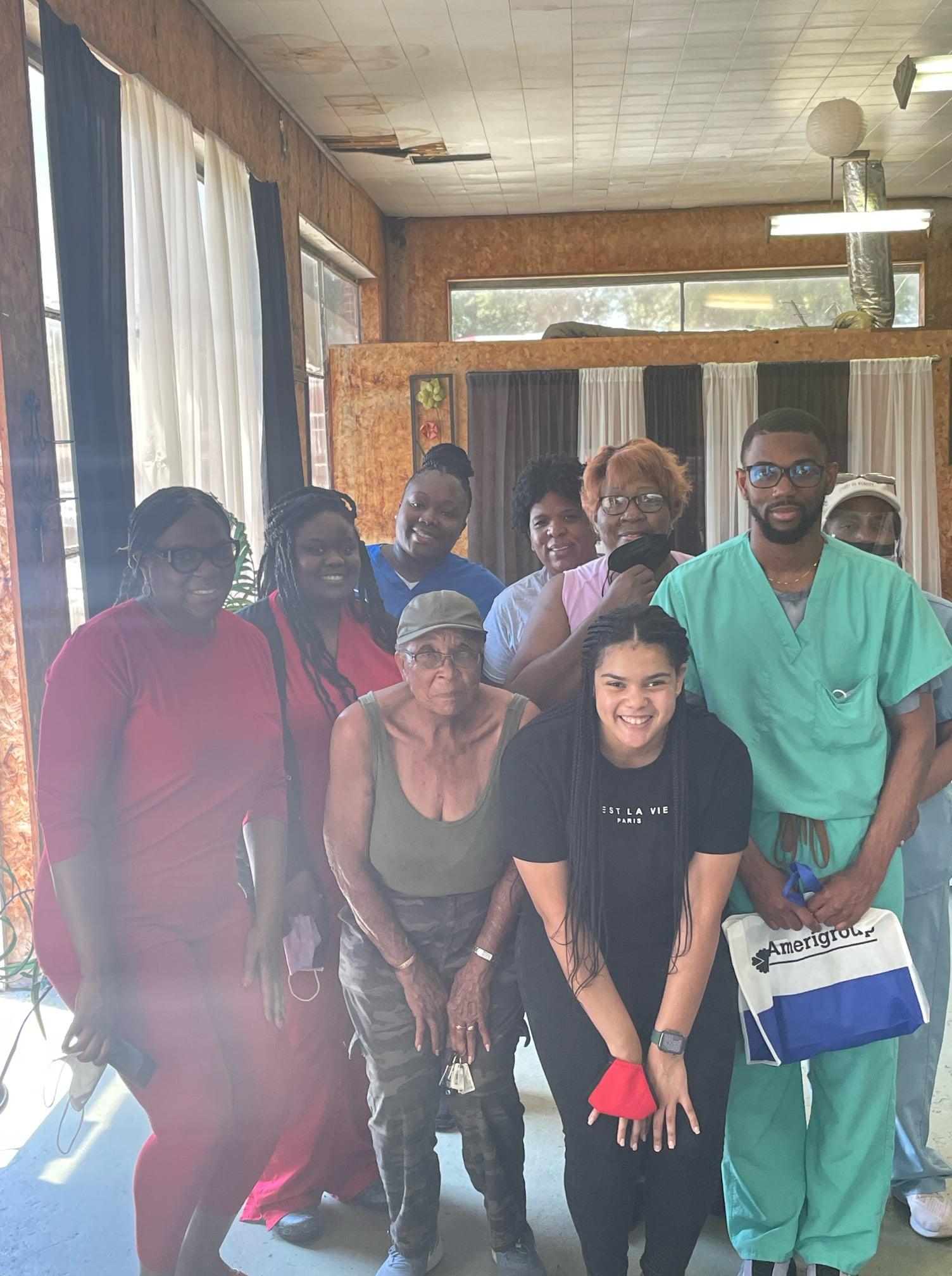 A group of African American people post together and smile